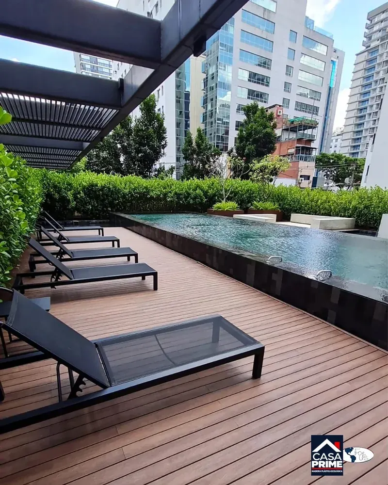 Deck em madeira plástica ecológica junto à piscina de condomínio com espreguiçadeiras